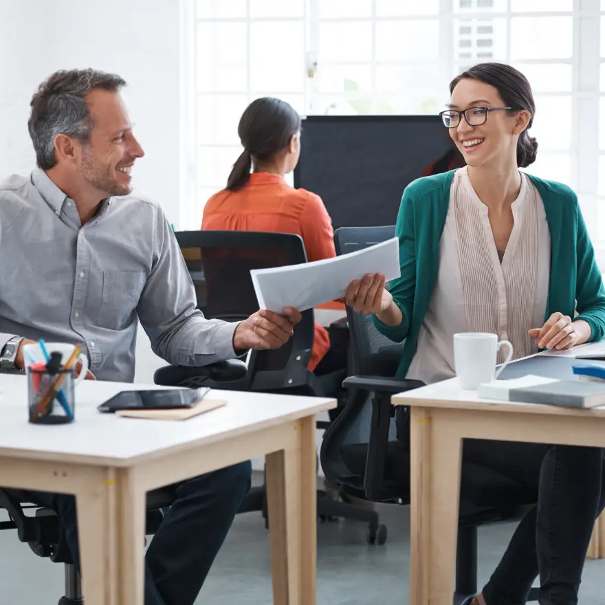 Un homme et une femme assis à une table, discutant ensemble dans un cadre convivial.