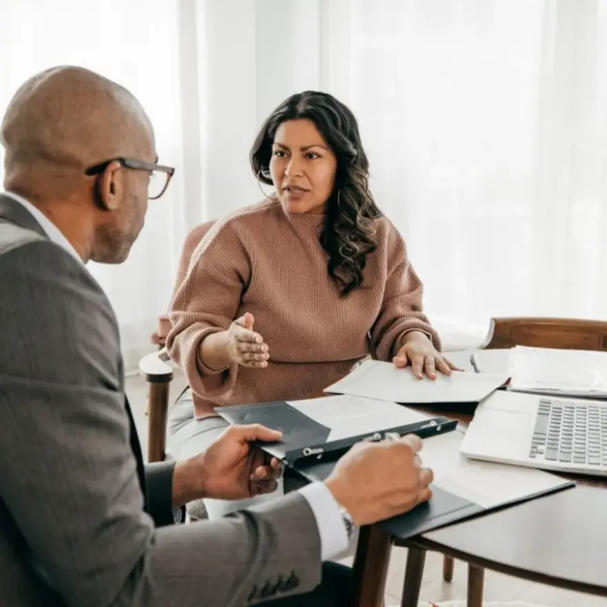 Un groupe de personnes collaborant dans un bureau, entouré d'ordinateurs et de documents de travail