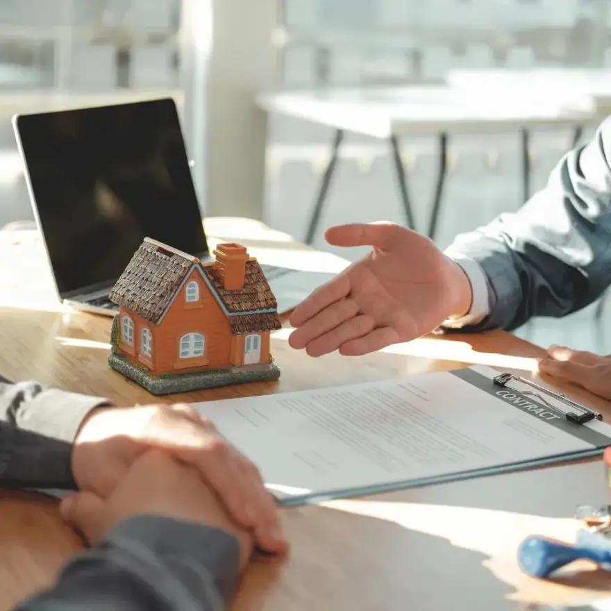 Un agent immobilier et un client se serrent la main, symbolisant un accord ou une transaction réussie.