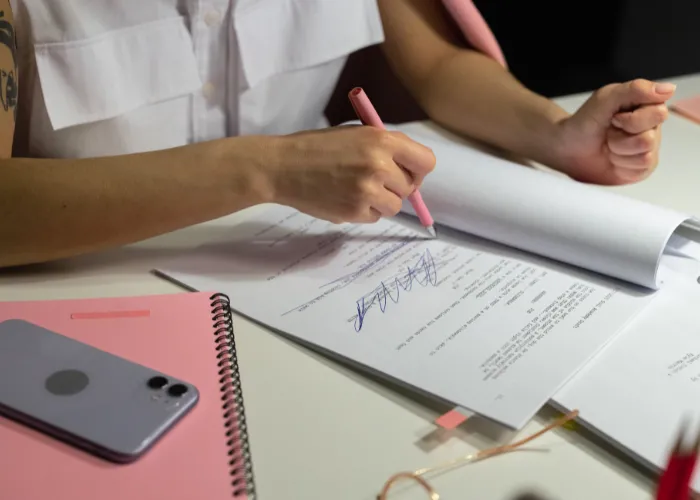Une personne écrit sur un morceau de papier avec un stylo